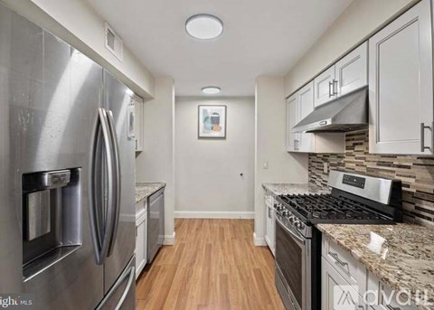 A kitchen with a refrigerator, oven, and stove top.