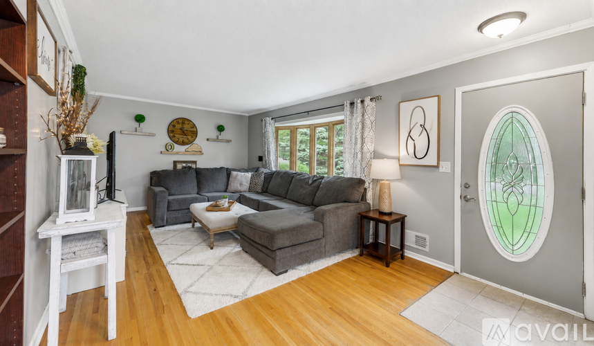 A living room with a grey couch and a wooden floor.