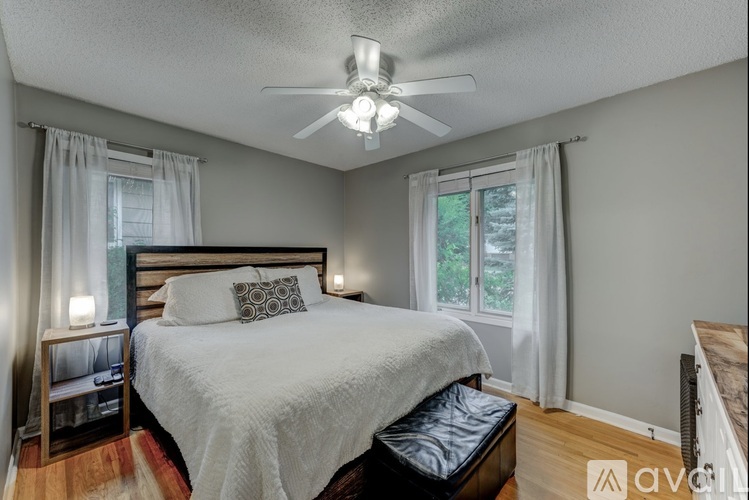 A bedroom with a large bed and a ceiling fan.