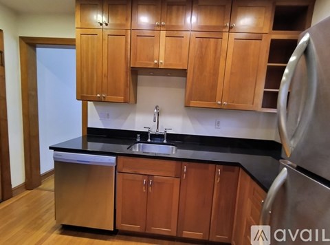 A kitchen with wooden cabinets and a black countertop.