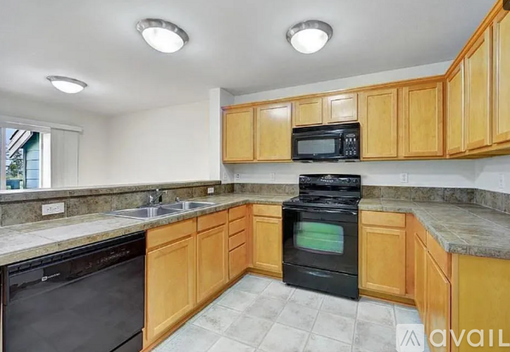 A kitchen with wooden cabinets and black appliances.
