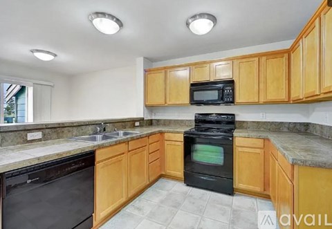 A kitchen with wooden cabinets and black appliances.