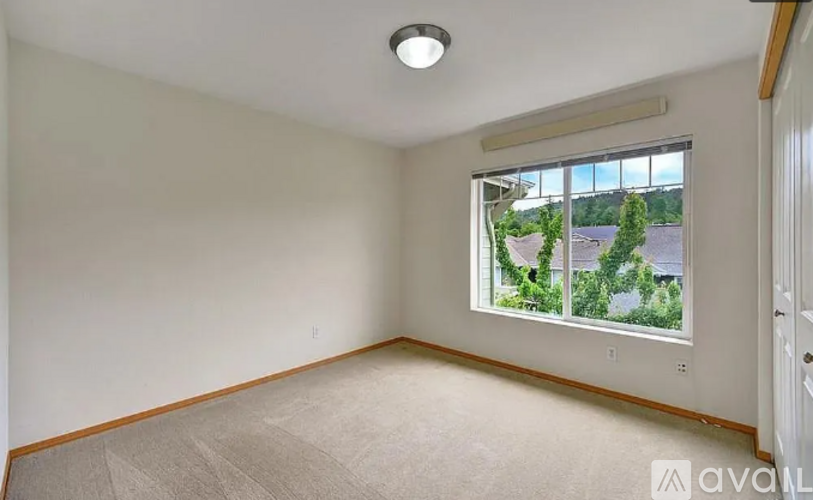 A room with a window showing a view of a residential area.