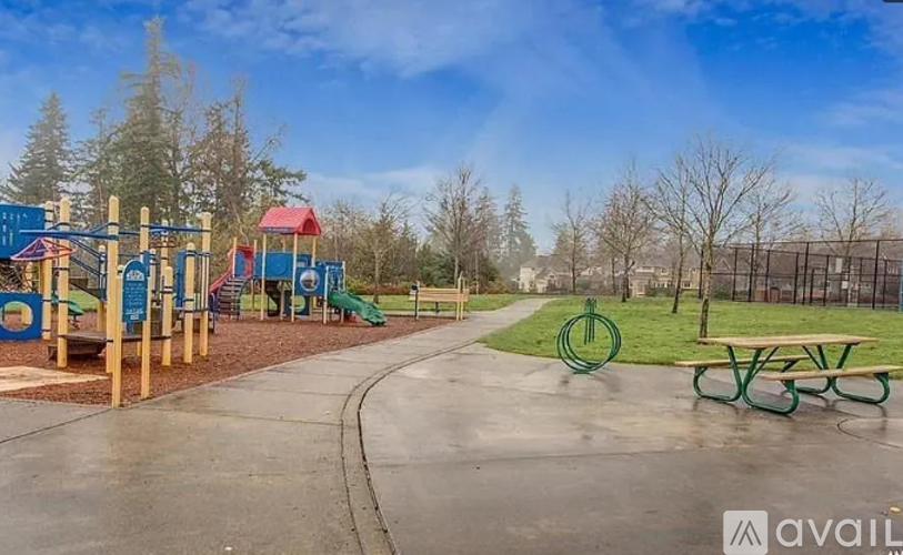 A playground with a slide, swings, and a seesaw.