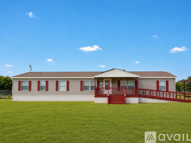 A house with a red front porch and a fence in the front yard.