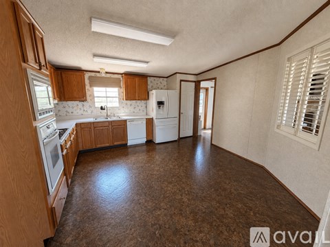 A kitchen with brown cabinets and a white fridge.