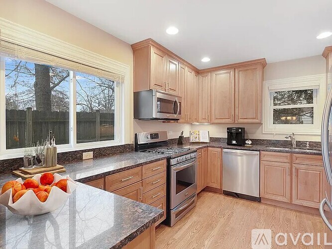A kitchen with wooden cabinets and a granite countertop.