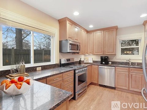 A kitchen with wooden cabinets and a granite countertop.