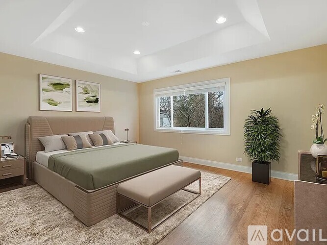A bedroom with a large bed and a bench in front of it.