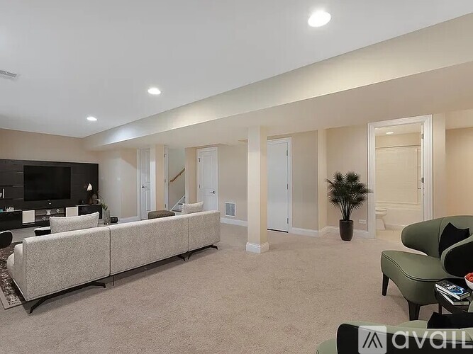A living room with a couch, a chair, and a television.