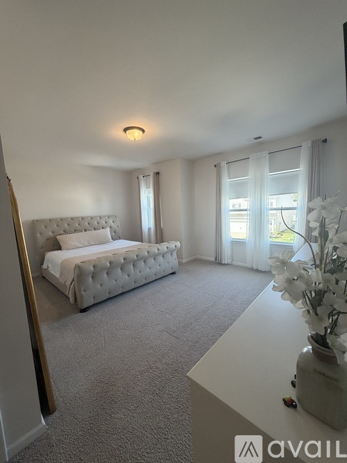 A bedroom with a large bed and a carpeted floor.