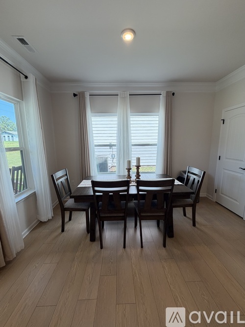 A dining room with a table set for four.