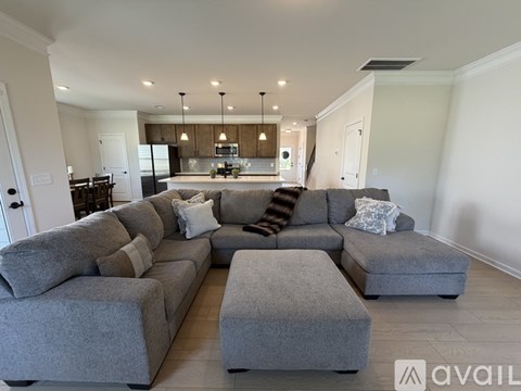 A modern living room with a grey sectional sofa and ottomans.
