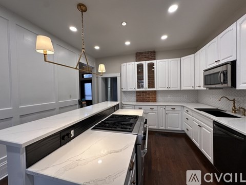 A modern kitchen with white cabinets and a marble countertop.