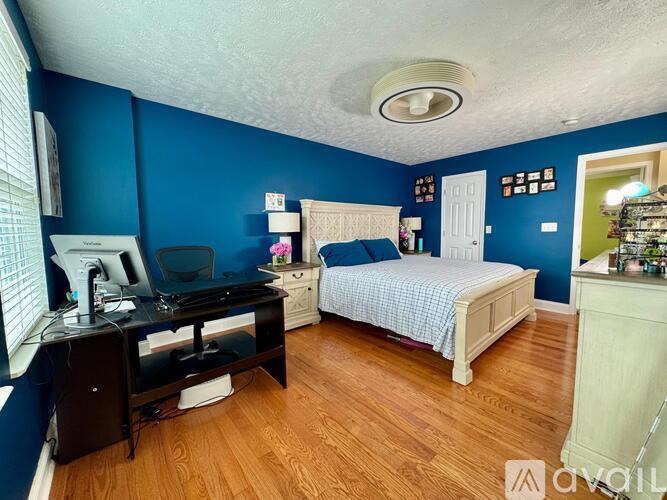 A bedroom with a bed, desk, and chair.
