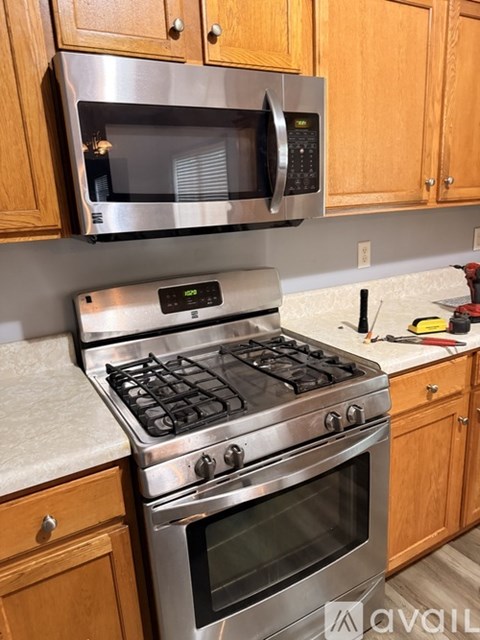A kitchen with a stove and microwave above it.