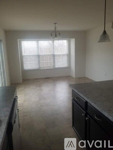 A kitchen with black cabinets and a marble countertop.