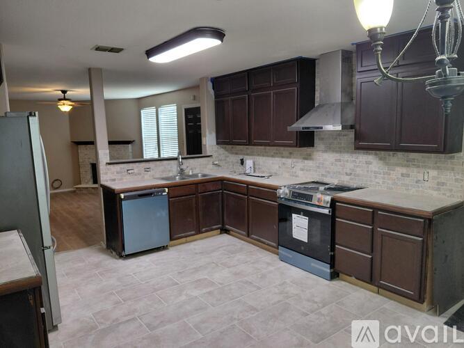 A kitchen with brown cabinets and a white brick backsplash.