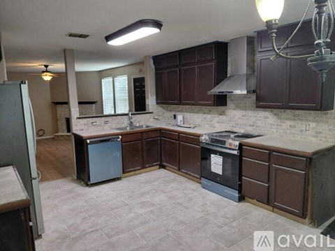 A kitchen with brown cabinets and a white brick backsplash.