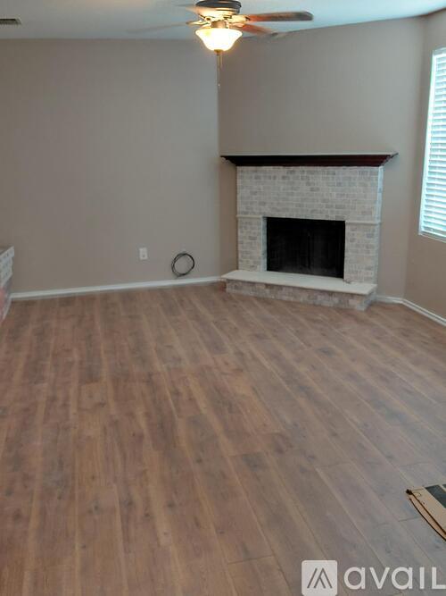 A living room with a fireplace and wood flooring.