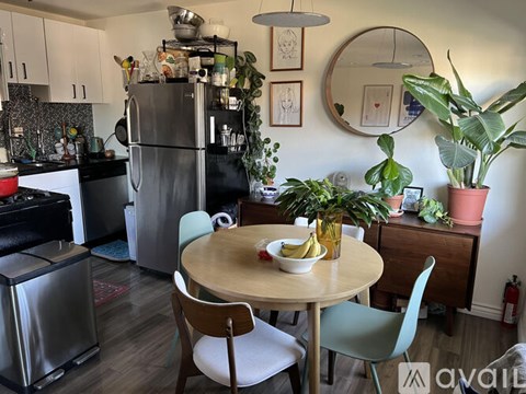 A kitchen with a table and chairs and a refrigerator.