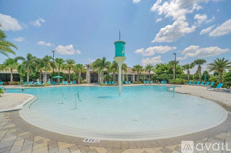 A large swimming pool with a diving board and palm trees in the background.