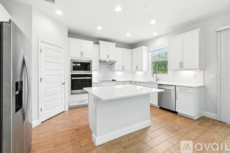 A modern kitchen with white cabinets and a central island.