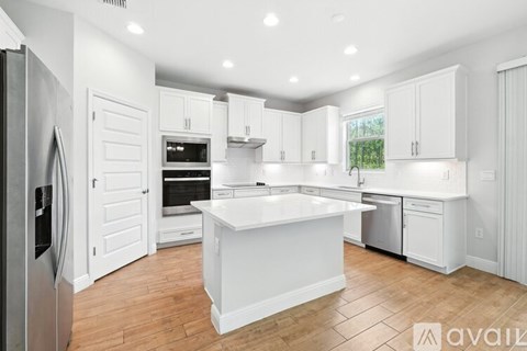 A modern kitchen with white cabinets and a central island.