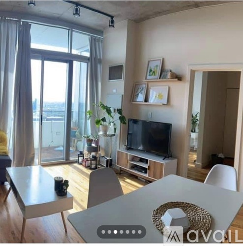 A modern living room with a large window and a flat screen TV.