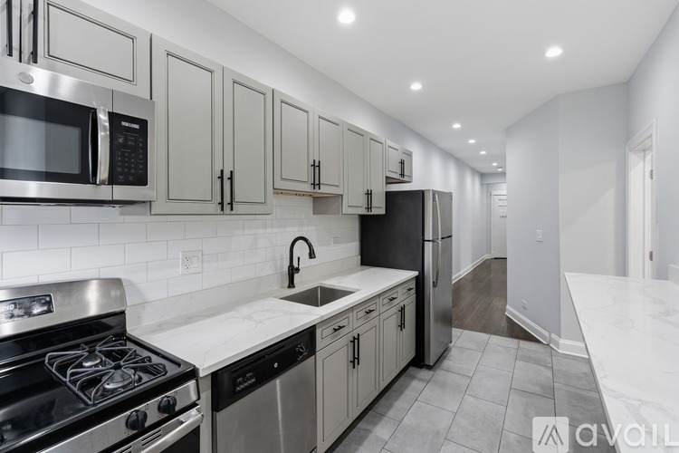 A modern kitchen with stainless steel appliances and white cabinets.