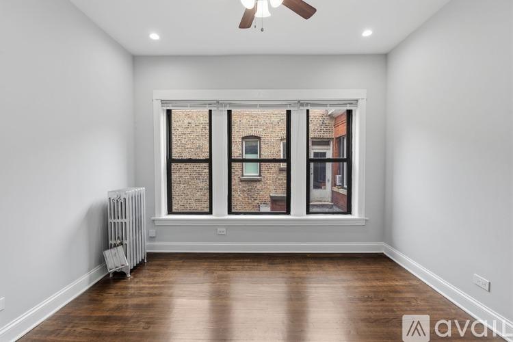 A room with a window showing a brick building outside.