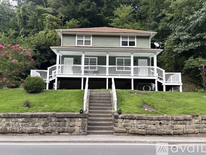 A house with a porch and stairs leading up to it.