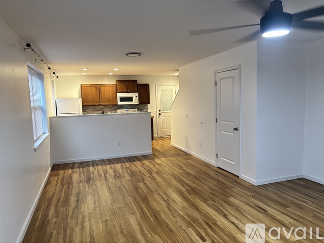 A room with wooden flooring and a ceiling fan.
