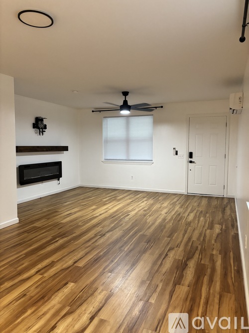 A room with wooden flooring and a ceiling fan.