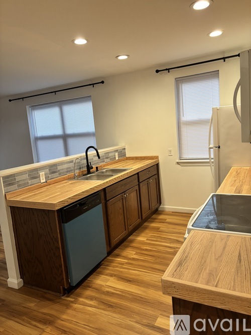 A kitchen with wooden cabinets and a wooden countertop.