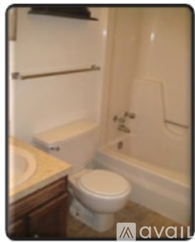 A white toilet sits next to a bathtub in a bathroom.