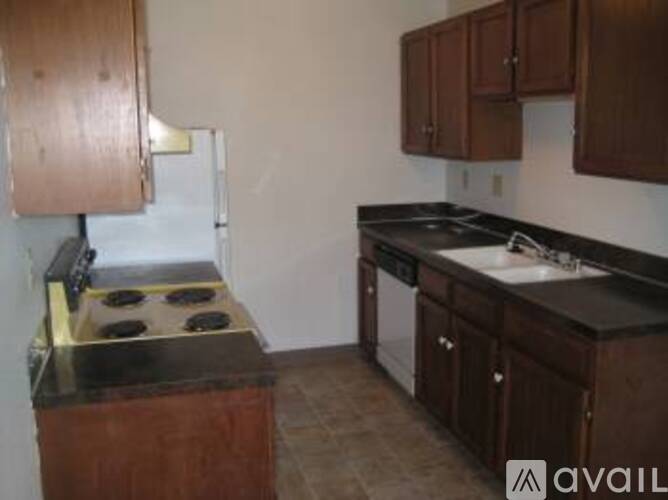 A kitchen with brown cabinets and a black stove top.