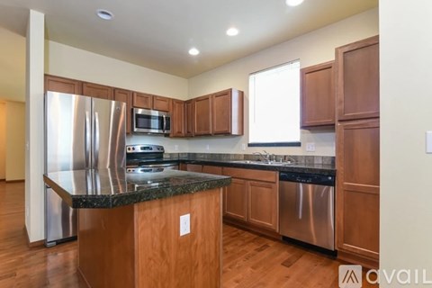 A kitchen with wooden cabinets and a granite countertop.