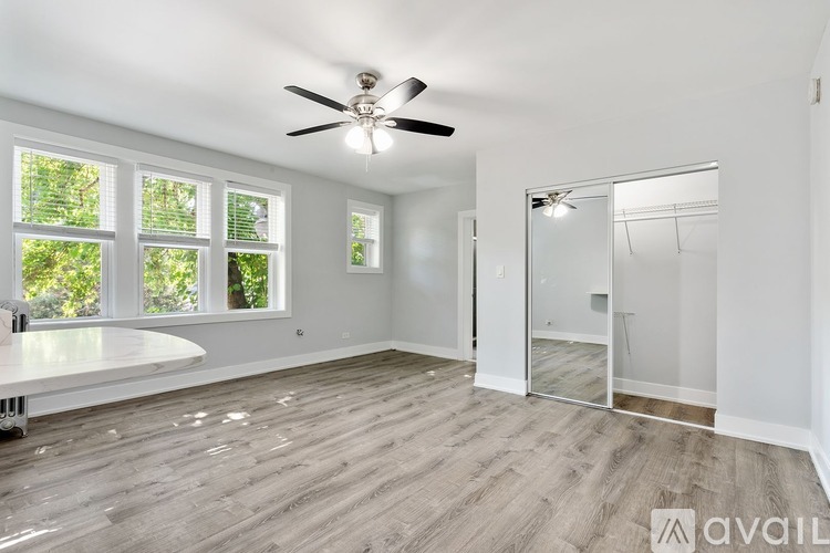 A spacious room with a ceiling fan and a large window.