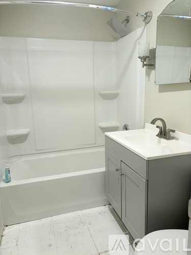A white bathroom with a white tub and sink.