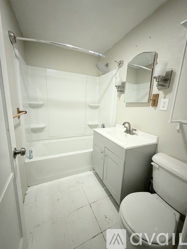 A white bathroom with a toilet, sink, and bathtub.
