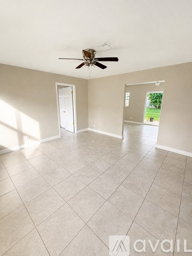 A room with a ceiling fan and tile flooring.