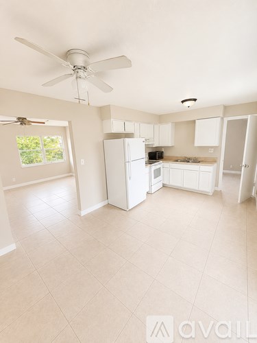 A kitchen with white appliances and cabinets.