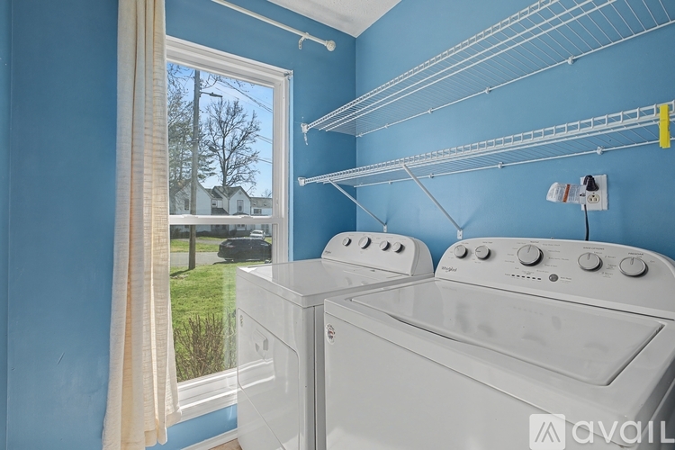 A laundry room with a washer and dryer and a window.