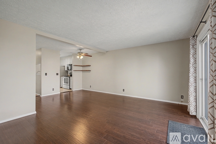 A room with wooden floors and a ceiling fan.