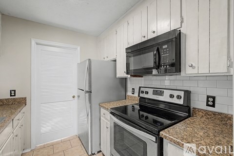 A kitchen with a black microwave above a stove.