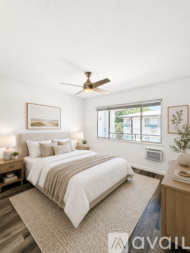 A bedroom with a large bed and a ceiling fan.