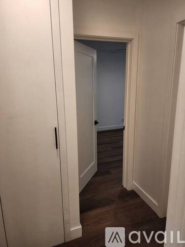 A hallway with a door on the left and another door on the right.