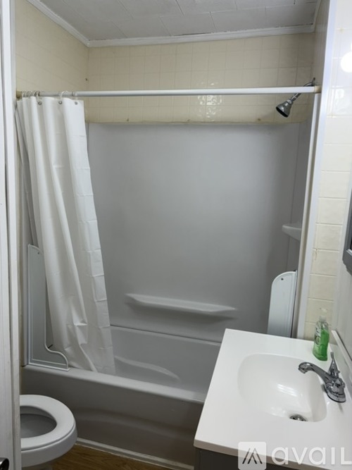 A white sink is on the right side of a white toilet in a white bathroom.