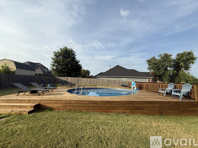 A backyard with a pool and deck.